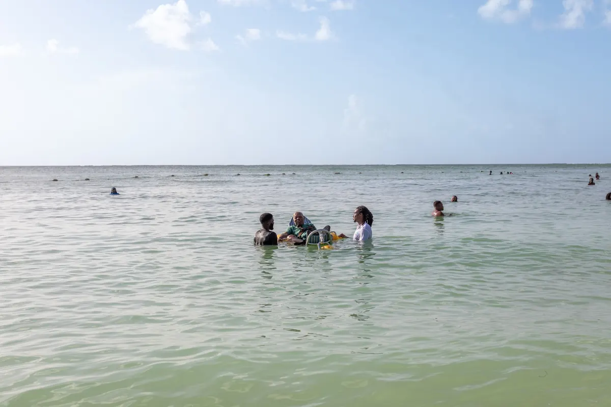Wellness Express team supporting a client during an accessible beach outing in Tobago