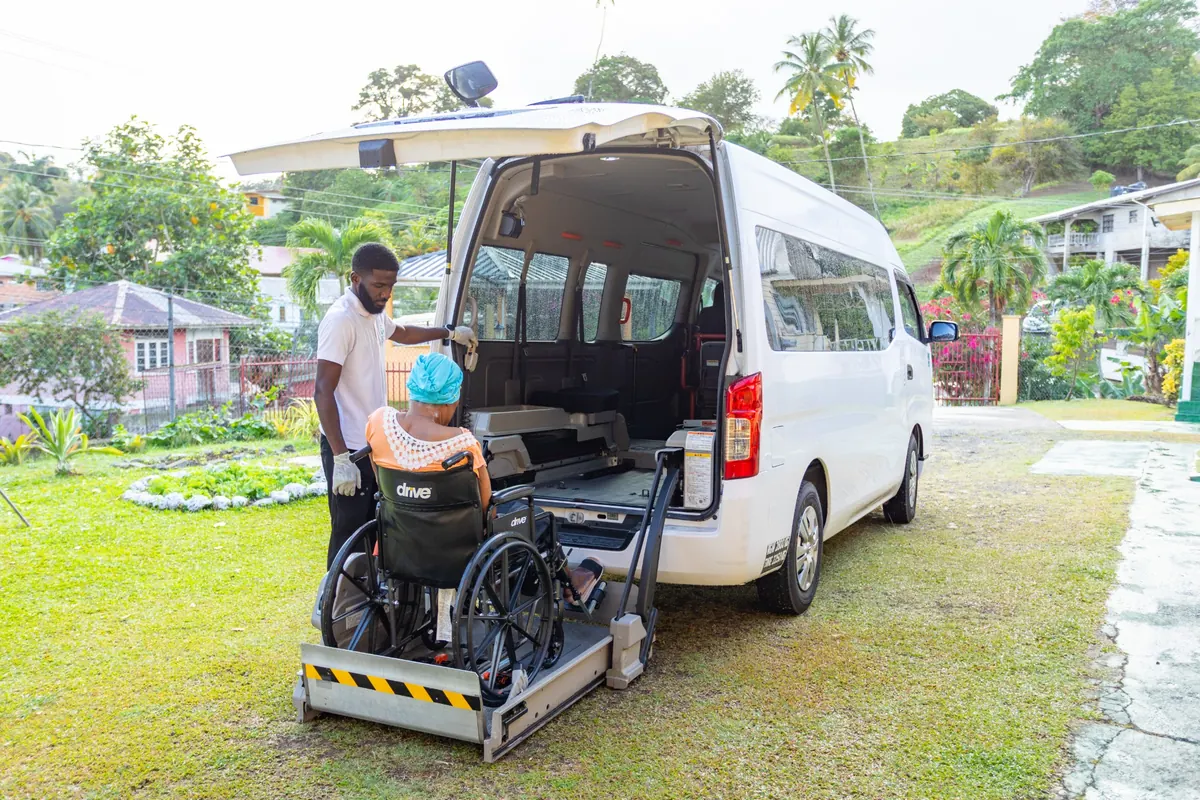 Wellness Express team assisting a client with supported hydrotherapy in the sea in Tobago